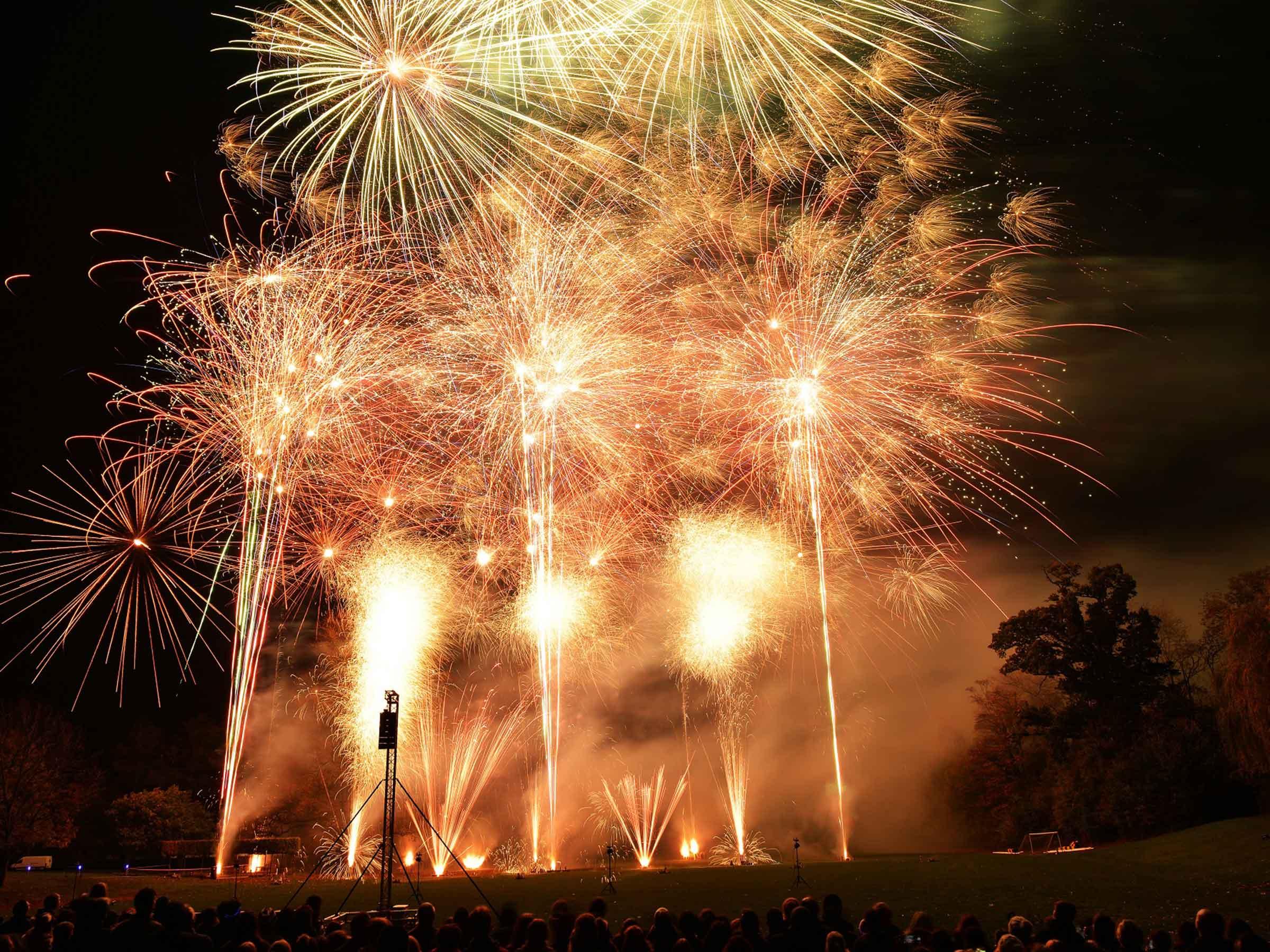 A high-end fireworks display synchronised with drones and lighting over a venue